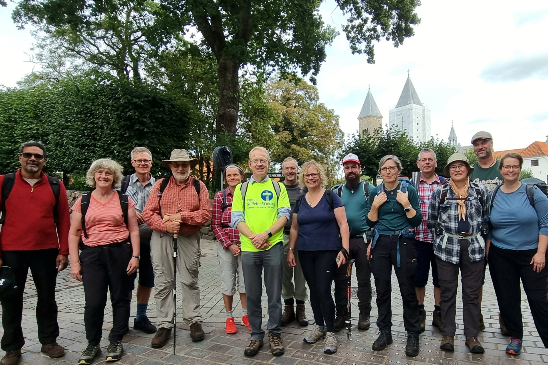 Group of people in walking gear posing for a group shot in a Danish town on a cloudy day