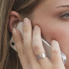A woman holding a mobile phone up to her ear