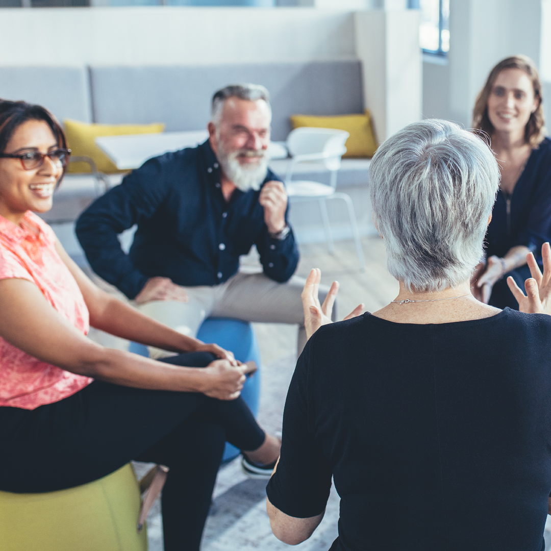 A woman training a group of engaged, smiling people