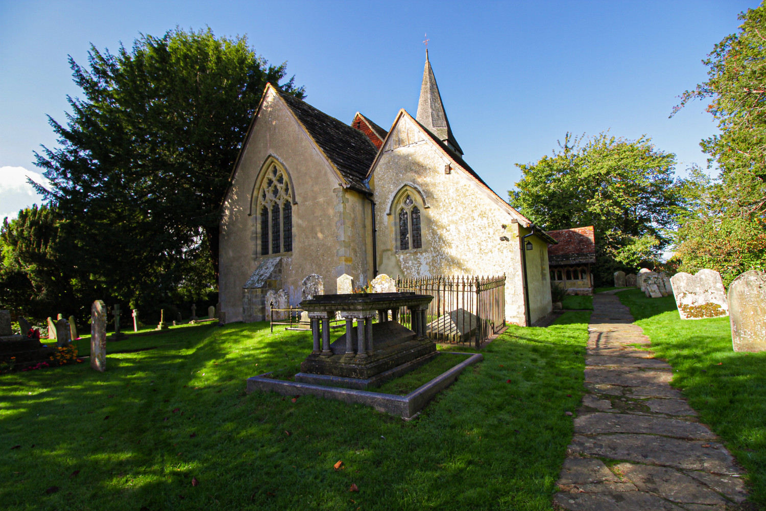 Exterior of a rural church and graveyard in the sunshine