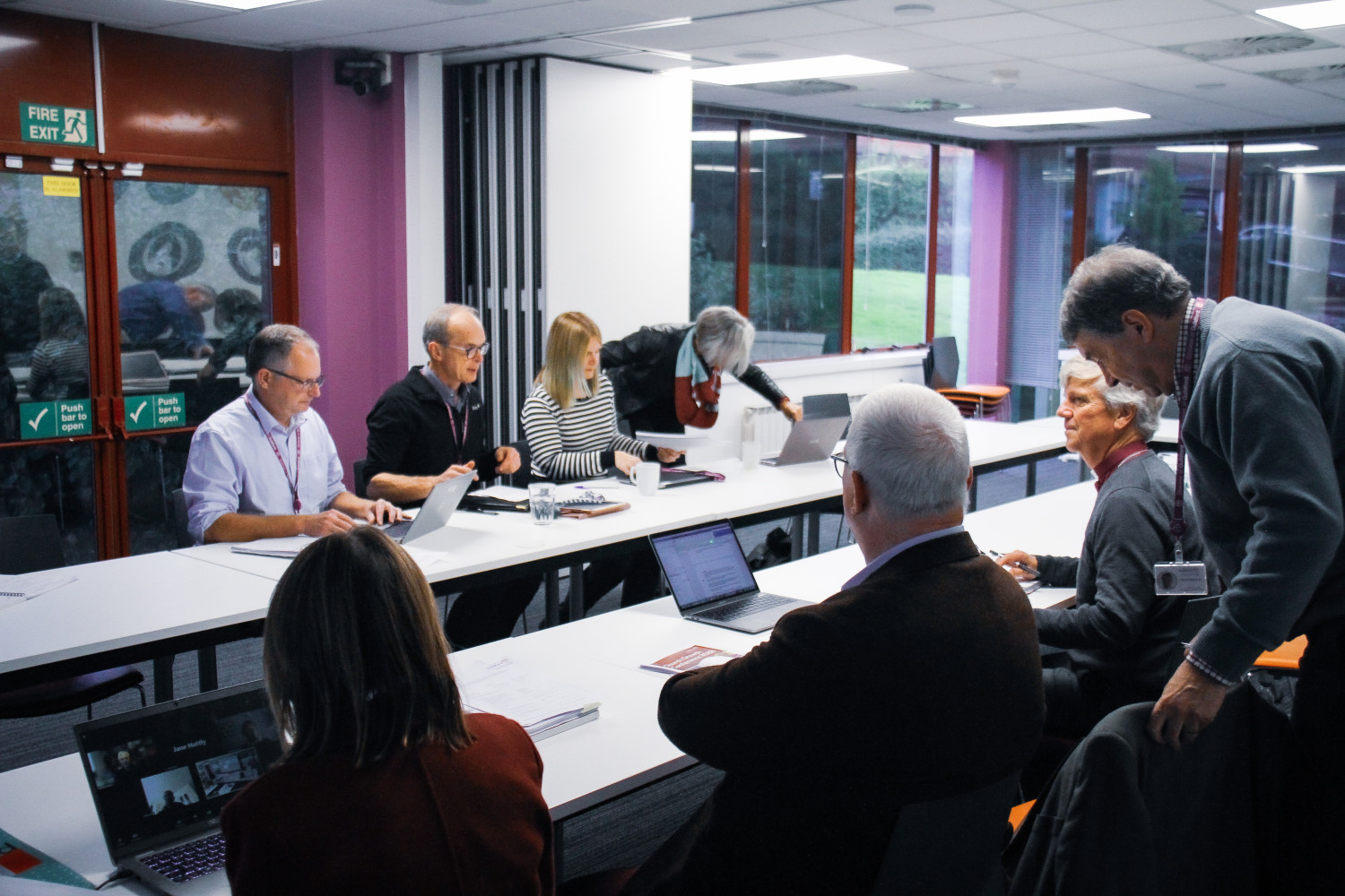 Diocesan staff sat in a meeting room at desks with laptops