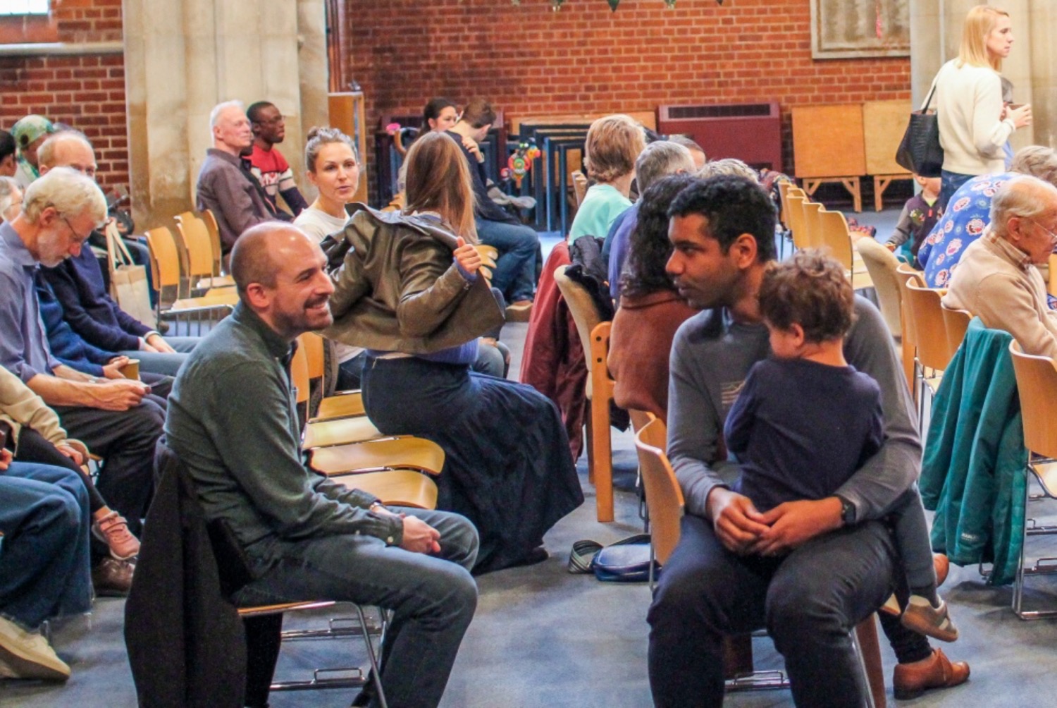 People of all ages sitting together ahead of a church service in a conversation