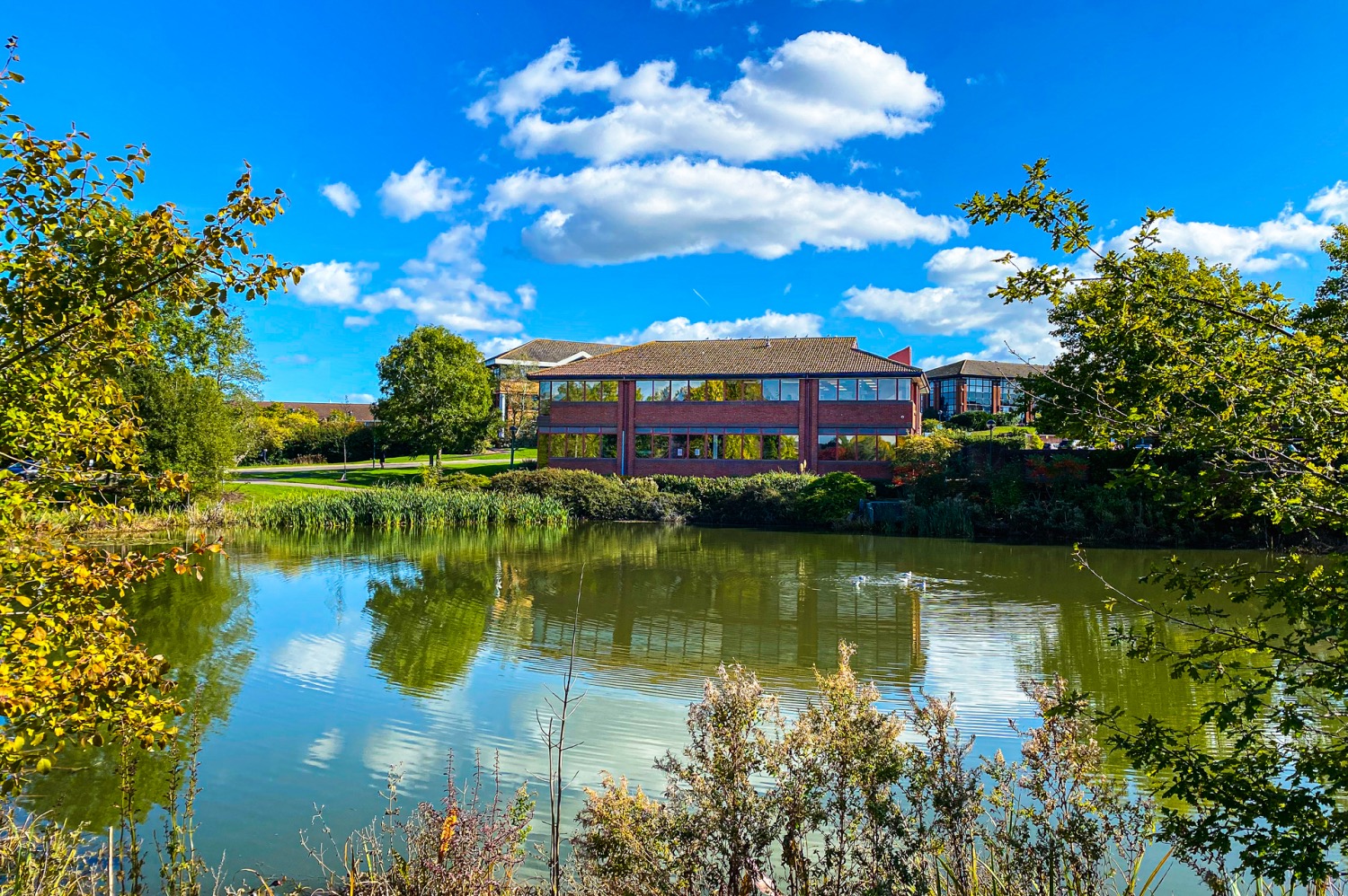 Across the lake to Church House Guildford with blue skies