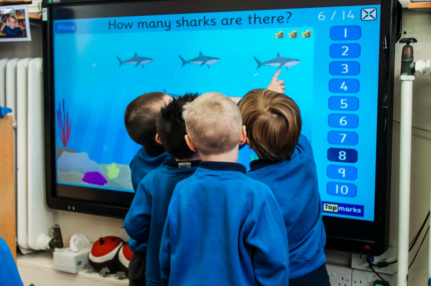 School children pointing at an interactive board