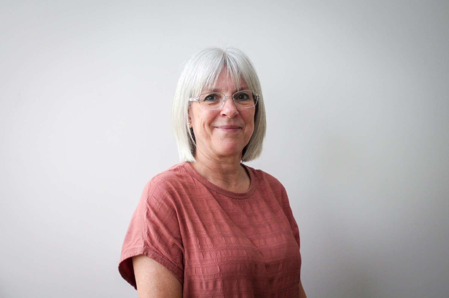 Profile of Wendy Harris smiling wearing a salmon short sleeved shirt