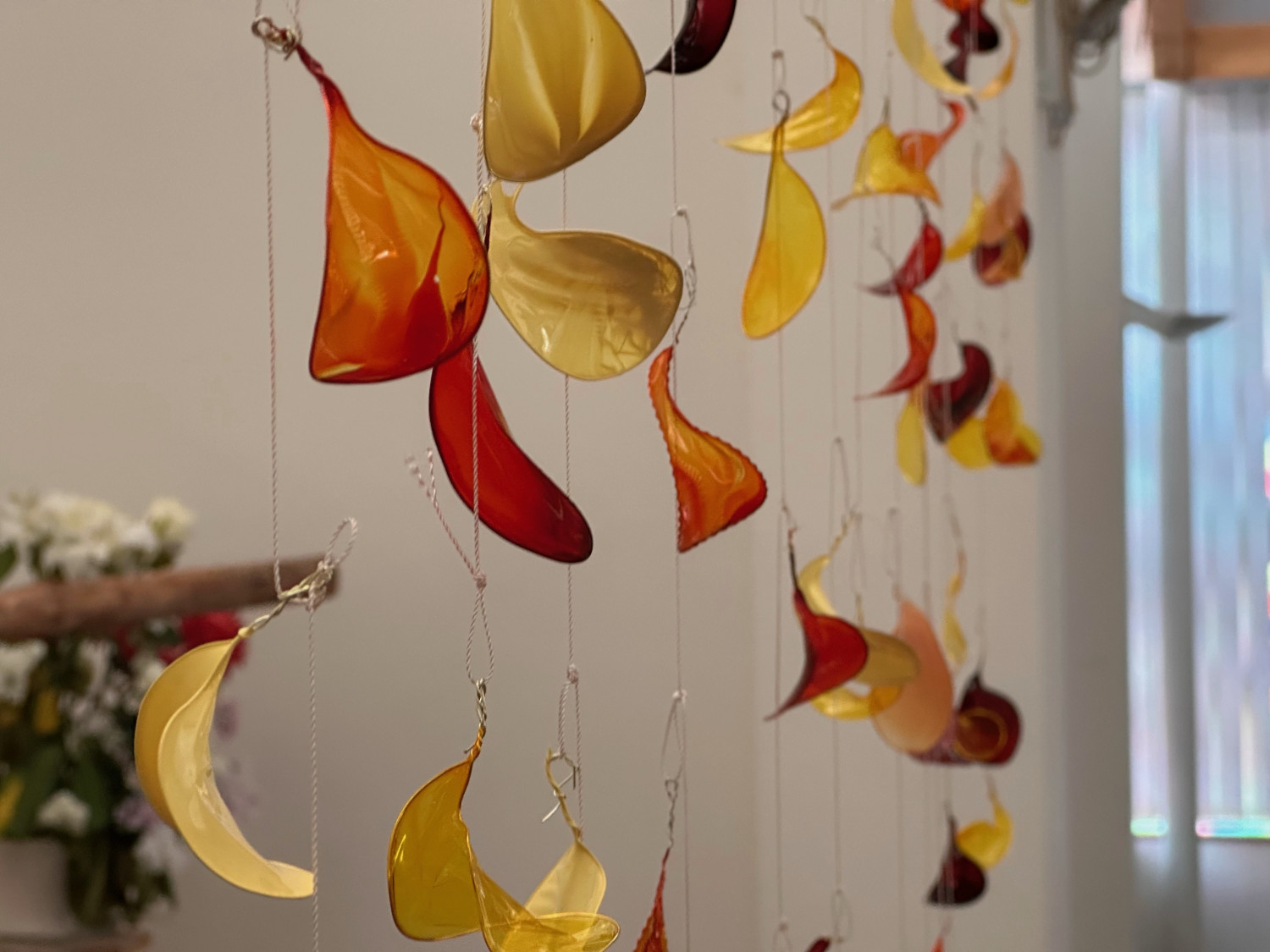 Close up of flame shape resin pieces hanging as part of an art installation